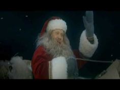 a man dressed as santa claus waves to the crowd