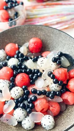 a bowl filled with red, white and black fruit