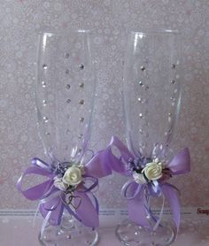 two wine glasses decorated with flowers and ribbons