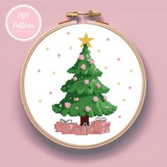 a cross stitch christmas tree with pink flowers