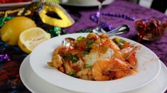 a white plate topped with food on top of a purple table cloth next to other plates