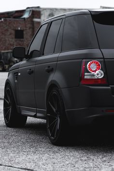 the rear end of a black range rover parked in a parking lot