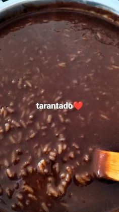 a wooden spoon stirring some food in a pot with the word tarantado written on it