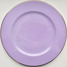 a purple plate with gold rim on a white surface