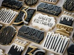 decorated cookies with black and white icing are arranged on a table together, including one that says happy birthday