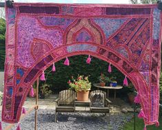 an outdoor area with pink and purple decorations on the outside, including a bench and table