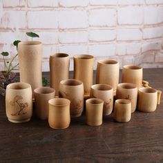 a group of wooden cups sitting on top of a table next to a brick wall