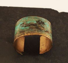 Our wide bronze cuff is hand forged and given a unique textured finish. The piece is then given a rich verdigris patina which ranges in color from black, to deep browns and vibrant greens. The aging process creates a different, organic patina on each piece. No two bracelets are exactly alike. A true one of a kind just like you. This is a great idea for a bronze anniversary gift. Each piece is sealed to protect it's finish. However, to preserve the patina it is best not to wear the piece while sw Bronze Brass Bracelet With Patina, Bronze Brass Bracelets With Patina, Artistic Patina Cuff Bracelet As Gift, Artistic Patina Cuff Bracelet Gift, Artisan Bronze Patina Bracelets, Vintage Brass Cuff Bracelet With Patina, Vintage Bronze Cuff Bracelet With Patina, Bronze Patina Cuff Bangle Bracelet, Artisan Bronze Bracelets With Patina