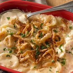 a red bowl filled with pasta and meat covered in gravy