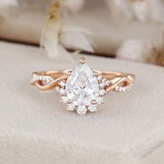 an engagement ring with a pear shaped diamond in the center