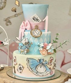 a multi - tiered cake decorated with an alice in wonderland theme