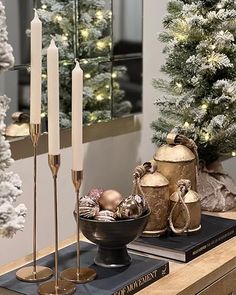 a table topped with candles and ornaments next to a christmas tree