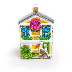 a ceramic house ornament decorated with flowers and birds