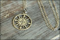 "A gorgeously detailed solid sterling compass rose hangs from a sterling silver chain. The \"rose\" term is derived from the points on the compass, resembling a flower. This compass is used to chart winds and has appeared on maps and charts since the 1300s. Charm is also available in sterling plated bronze on a sterling chain and gold-toned solid bronze on a gold-filled chain. *Compass rose pendant measures about 27mm tall by 20mm wide *Sterling silver or gold filled chain measures about 16 inch Spiritual Compass Pendant Jewelry, Spiritual Compass Design Jewelry Gift, Silver Medallion Charm Necklace With Compass Design, Silver Medallion Jewelry With Compass Design, Symbolic Compass Design Round Pendant Jewelry, Symbolic Compass Pendant Jewelry, Symbolic Compass Design Pendant Jewelry, Symbolic Sterling Silver Jewelry With Compass Design, Symbolic Sterling Silver Necklace With Compass Design