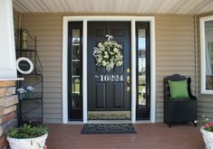 the front door is decorated with wreaths and potted plants