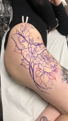 a woman laying on top of a bed covered in tattoos