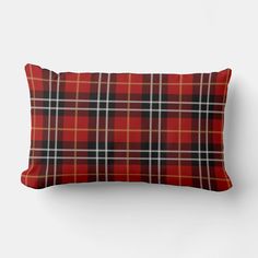 a red and black plaid pillow on a white wall