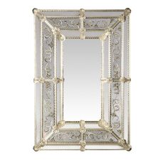 a decorative mirror with ornate designs on the front and sides, hanging from a white wall