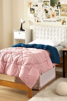 a bed with pink and blue comforters in a bedroom