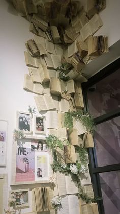 many books are stacked on top of each other with plants growing out of the pages