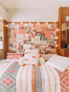 a bed with many pillows on top of it in a room filled with pictures and lights