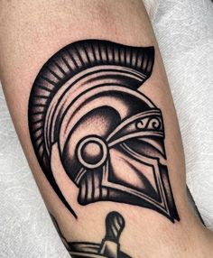 a man's arm with a spartan helmet tattoo on it