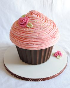 a pink frosted cupcake on a white plate