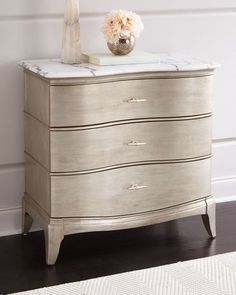 a white dresser with marble top and drawers