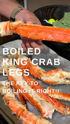 a person holding a large crab on top of a metal pan with the words boiled king crab legs