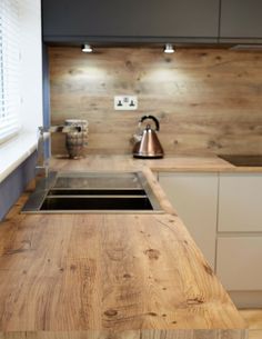 a wooden counter top in a kitchen next to a sink