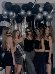 several women standing in front of balloons and streamers