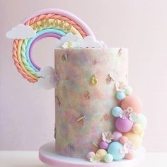 there is a cake decorated with pastel colors and rainbows on the top tier