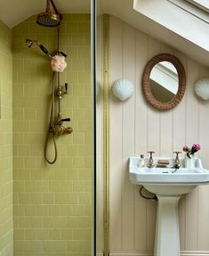 a bathroom with a sink, mirror and shower head