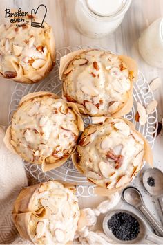 several muffins with icing and nuts on a plate