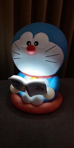 a lamp that has a cat reading a book