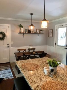 a kitchen with an island counter top and two lights hanging over the stovetop area