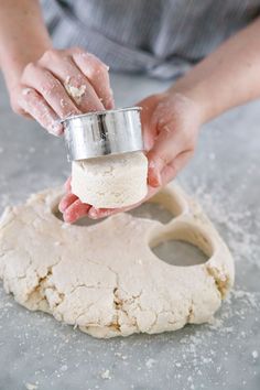 a person kneading dough on top of a table