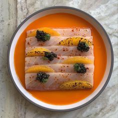 a plate that has some kind of food on it with oranges and blackberries