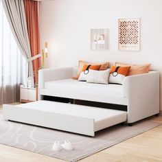 a living room with white furniture and orange pillows