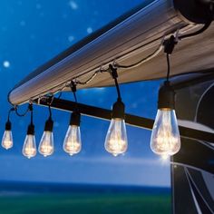 outdoor string lights hanging from the side of a house in front of a blue sky