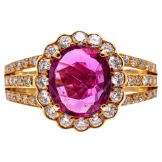 18k Yellow Gold Pink Sapphire And Diamond Cluster Ring This striking ring is a cluster style, set with a faceted oval shape, medium pink color lab created pink sapphire center, prong set. Surrounding the stone is a halo of round brilliant cut diamonds, set with a scalloped edge, and decorated with a three row, round faceted diamond set shank. The entire diamond weight for the ring is approximately 0.47 TCW. Marks: 18k Dimensions: 13/16" across the top x 1/2" wide Weight: 4.2 gross dwt Formal Pink Cluster Ring With Brilliant Cut, Classic Pink Diamond Cluster Ring, Classic Pink Cluster Ring With Center Stone, Elegant Pink Cluster Ring With Brilliant Cut, Luxury Pink Oval Cluster Ring, Classic Pink Cluster Ring For Formal Occasions, Pink Cluster Diamond Ring With Center Stone, Formal Pink Diamond Cluster Ring, Pink Cluster Ring With Brilliant Cut