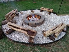 a fire pit made out of logs and gravel