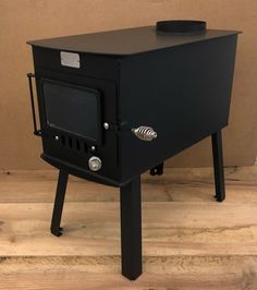 a black stove sitting on top of a hard wood floor next to a brown wall