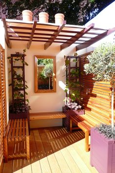 a wooden bench sitting under a window next to a planter filled with potted plants