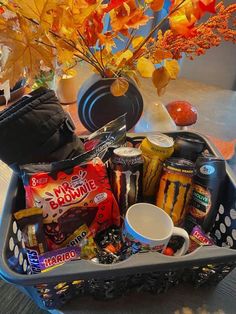 a basket filled with snacks and drinks on top of a table