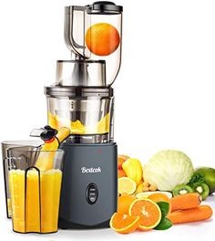 a blender filled with oranges and juice next to other fruit and vegetables on a white background