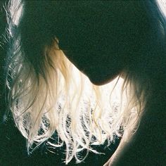 a close up of a woman's face with her hair blowing in the wind