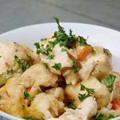 a white bowl filled with chicken and vegetables