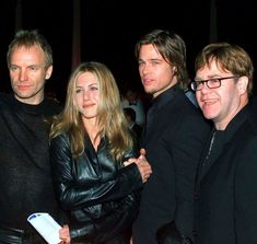 three men and a woman posing for the camera