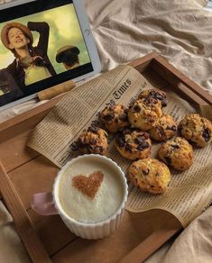 there is a tray with muffins and a cup of coffee on the table